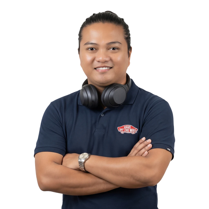 Richard Mendoza, smiling with arms crossed and headphones around his neck